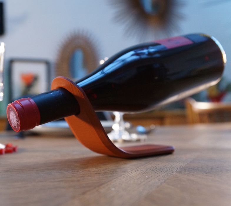 Support avec une bouteille de vin rouge en équilibre.