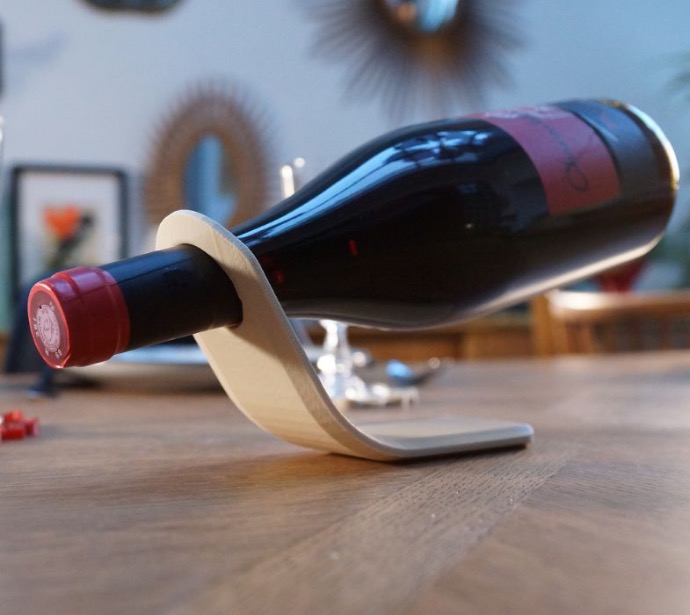 Support à vin avec design minimaliste, exposant une bouteille en suspension.