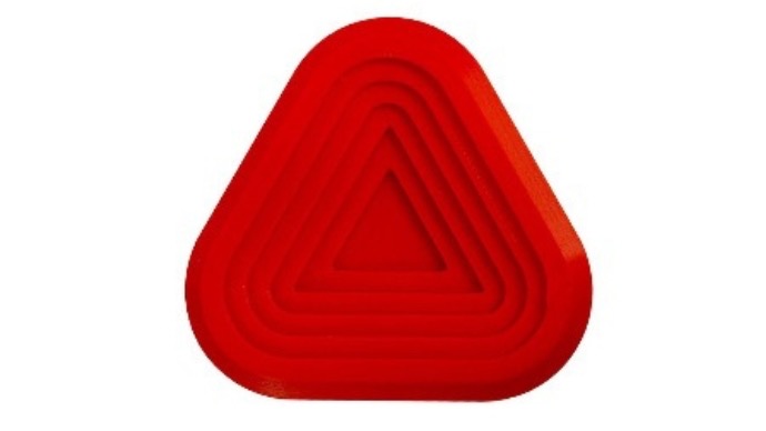 Patère murale rouge en forme de triangle avec relief concentrique.
